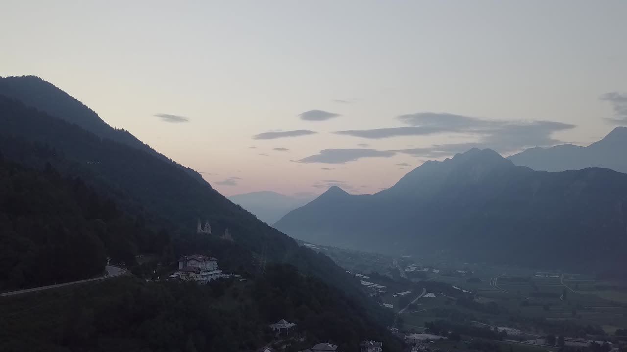 vista aérea de levico terme, italia durante el amanecer con drones volando hacia adelante