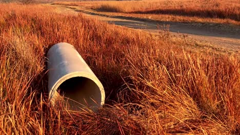 contractor offloads large concrete storm water pipes with teamwork and precision on a rural farm construction site