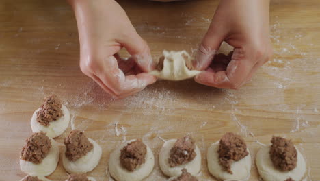 a professional baker makes dumplings with meat filling. delicious traditional ukrainian cuisine