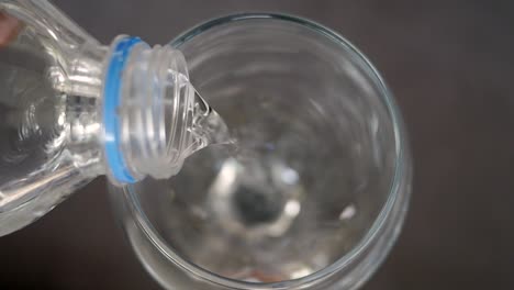 vertiendo agua de una botella en un vaso