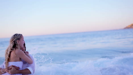 Pareja-En-La-Playa-Corriendo-Mientras-Se-Besa-Después-De-Ser-Golpeada-Por-Una-Ola.