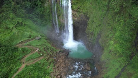 carretilla aérea de la cascada eco chontales que fluye hacia un estanque rocoso turquesa rodeado de una densa selva tropical, costa rica