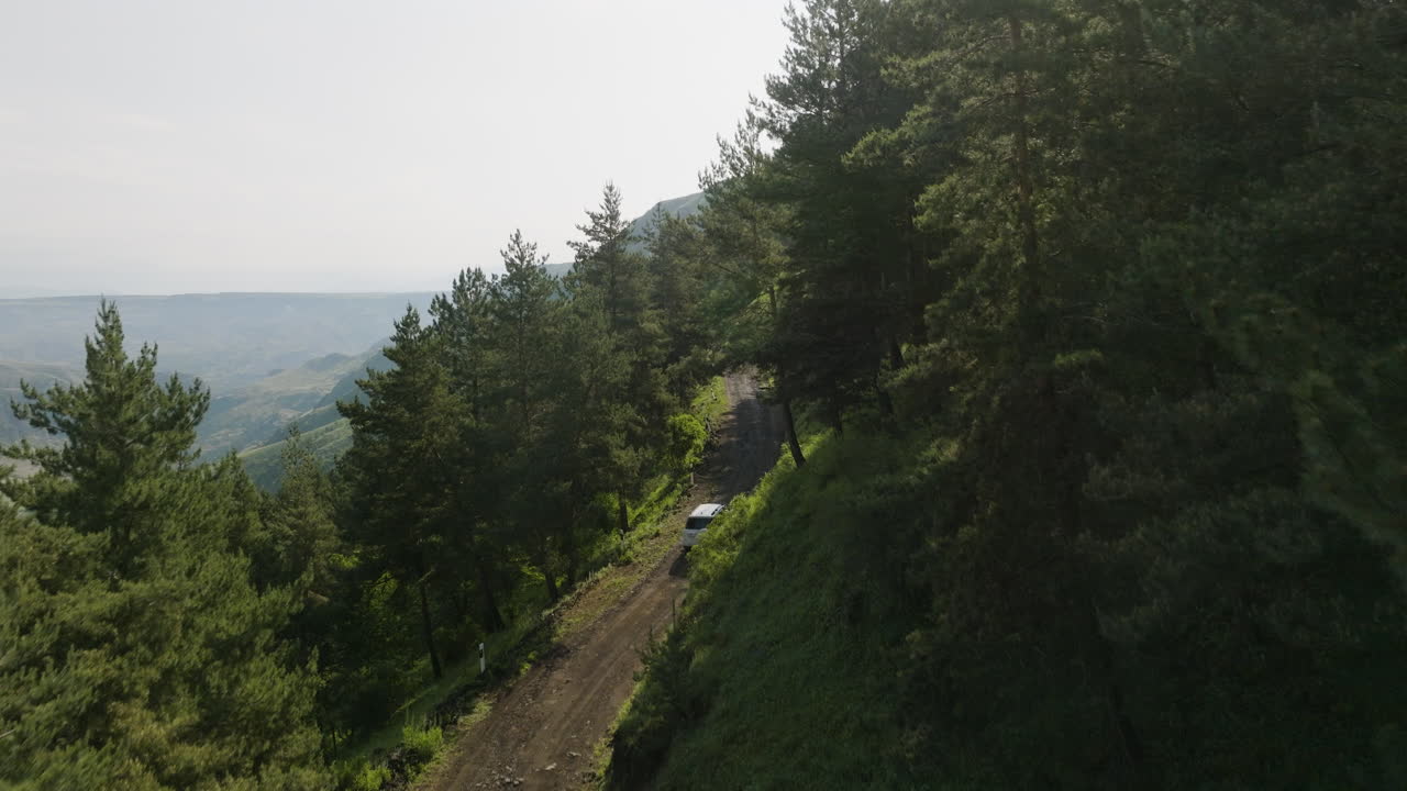 vista aérea de drones de un automóvil que conduce por una carretera de montaña que va al pueblo de apnia en samtskhe-javakheti, georgia