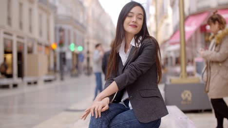 Woman-sitting-on-a-bench-in-town-waiting