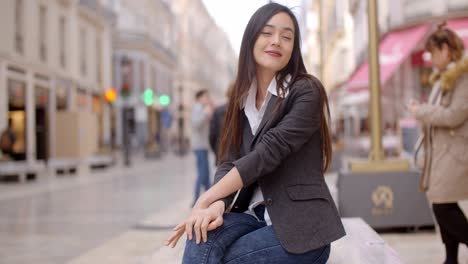 mujer sentada en un banco en la ciudad esperando