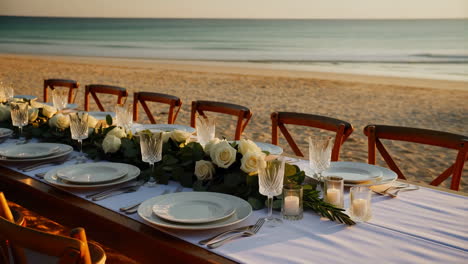 elegant beach dinner table set up at sunset