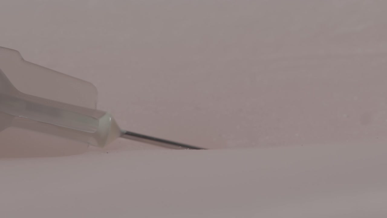 vista macro de la aguja de una jeringa que penetra en la piel de un paciente que recibe una inyección o vacunación