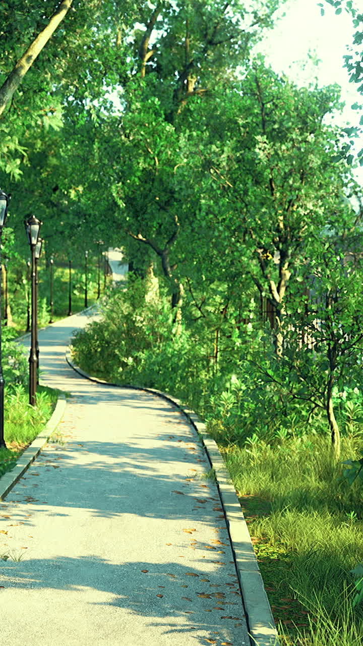 Walking path through green park with trees and lamps in daylight ...