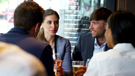 group of business colleagues meeting for drinks and socializing in bar after work