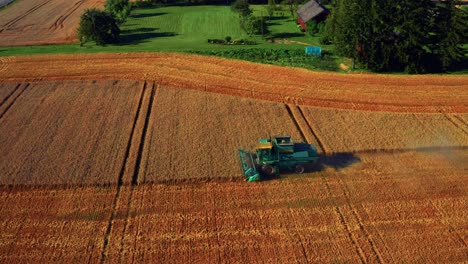 Arbeitender-Mähdrescher-In-Weitem-Ackerland-Während-Des-Sonnenuntergangs