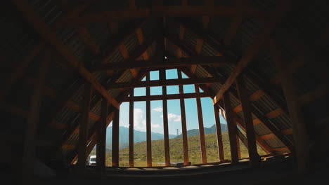 wooden house attic at mountain camp fpv. open garret with wood beam carcass under green roof at sports base on summer day. eco architecture at wild resort