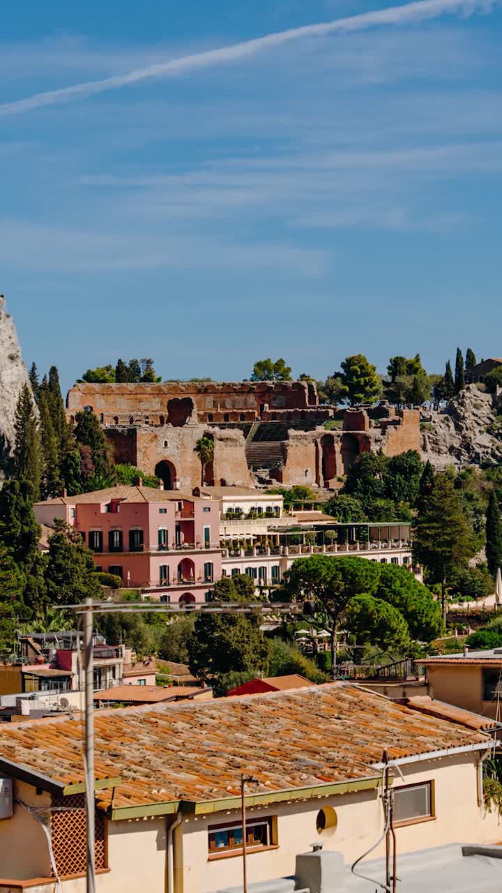 View to historic site of Taormina's ancient theater. Vertical timelapse video of a town in the mountains in Sicily.