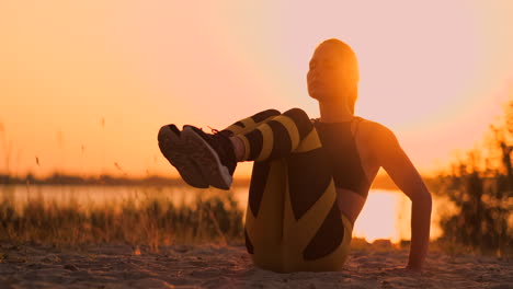 Fitness-woman-doing-crunches-at-the-beach.-Fitness-woman-doing-crunches-exercise-workout-towards-the-beach.-Female-fit-athlete-training-abdominal-midsection