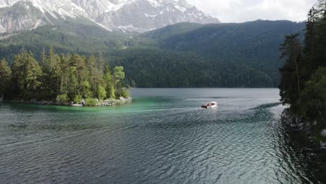 following a boat on lake eibsee from above during a sunny day