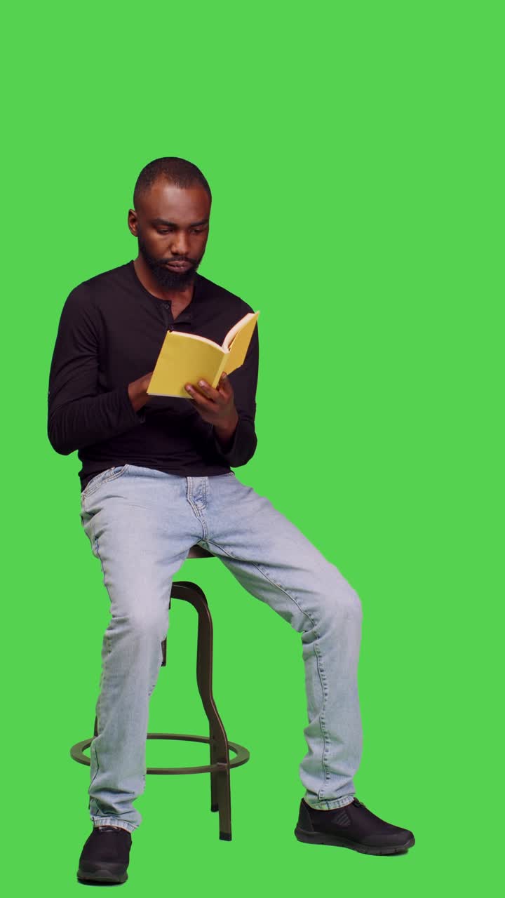 Vertical video: Side view of cheerful adult having story book in studio