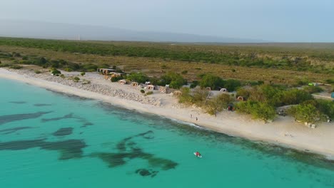 Vista-Aérea-Del-Exclusivo-Albergue-Natural-Eco-Del-Mar-Con-Alojamiento-En-Carpas-Ecológicas-Junto-Al-Agua-Turquesa-Del-Mar,-República-Dominicana,-Círculo-Aéreo-Aéreo