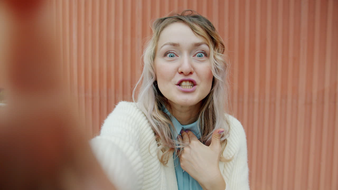 Woman Taking Selfies in Front of Pink Wall
