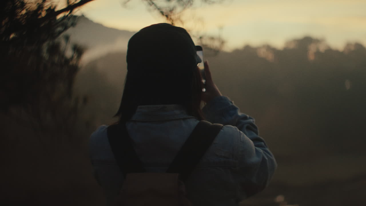 Woman Taking Pictures at Sunrise/Sunset in the Mountains