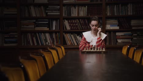 mujer jugando al ajedrez en una biblioteca