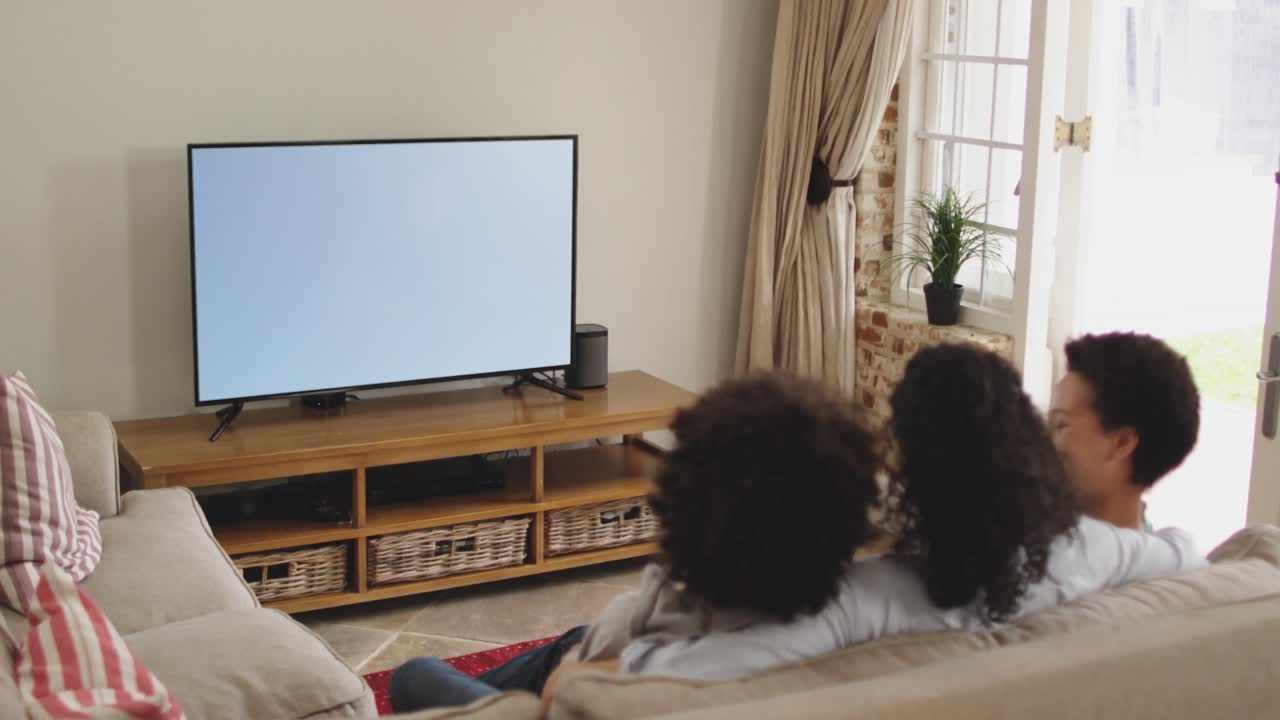 Famiglia felice seduta a casa insieme che guarda una partita di calcio in TV
