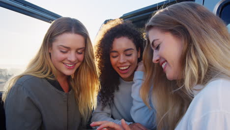 Mujeres-Adultas-Jóvenes-En-Un-Viaje-Por-Carretera-Usando-Un-Teléfono-Inteligente-En-Coche