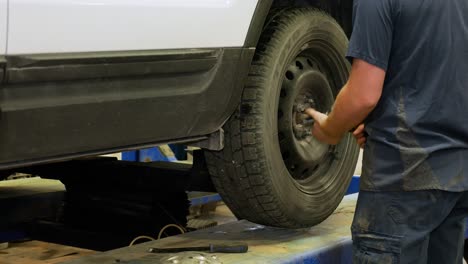 A-mechanic-removes-wheel-nuts-and-then-removes-the-wheel-from-a-vehicle