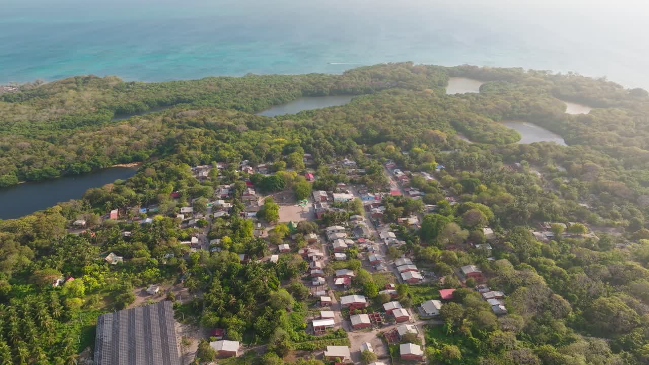 Drone view of Orika village on Isla Grande, Rosario Islands, Colombia. Traditional houses by the turquoise Caribbean Sea surrounded by lush tropical nature