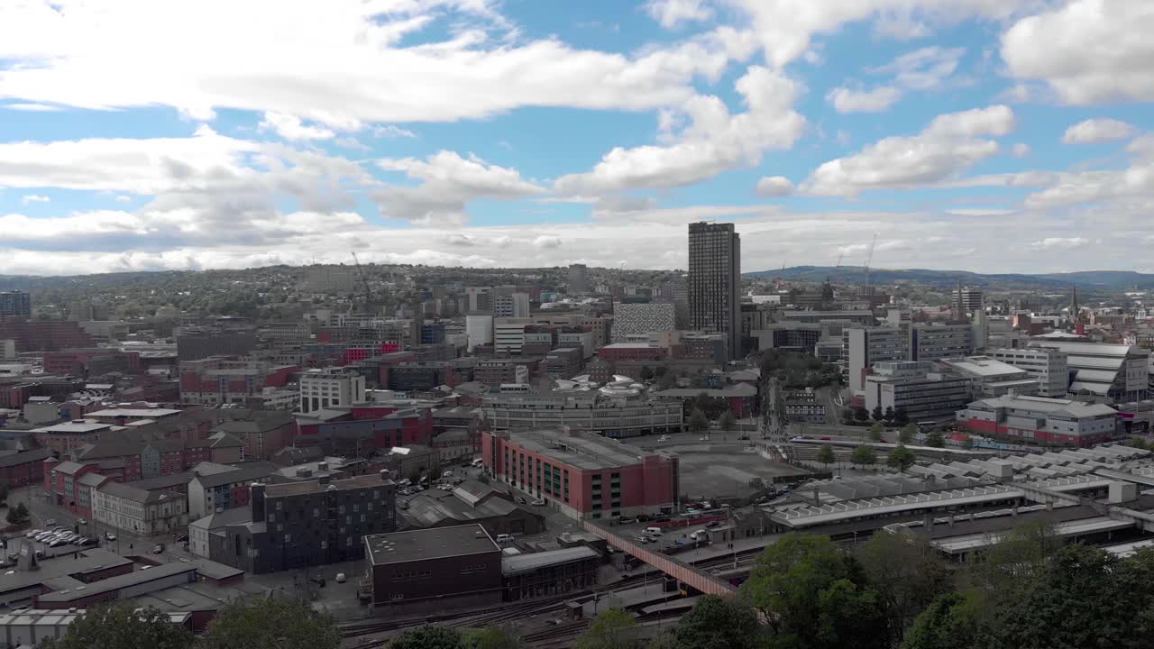 drone volando sobre la ciudad de sheffield verano día soleado 4k estación de tren sheffield hallam vívido tráfico y trenes viajando hacia atrás desde la ciudad