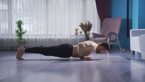 sportsman muscular young man doing push-ups at home. exercise moves.