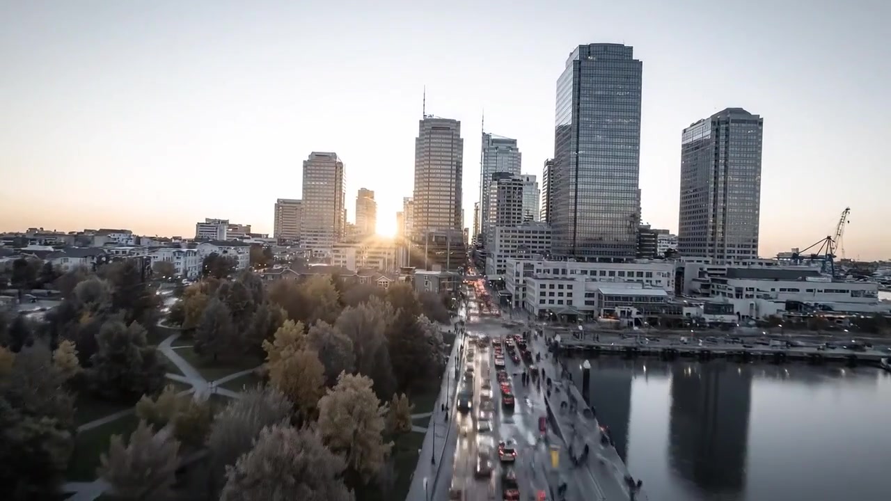 Ohromující proměna městské krajiny: Panorama města za soumraku a úsvitu s odrazy a světelnými stopami, zachycující pulzující rytmus života moderní metropole.