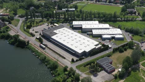 Moving-Aerial-Side-Shot-of-Industrial-Warehouse-Loading-Dock-where-Many-Truck-with-Semi-Trailers-Load--Unload-Merchandise