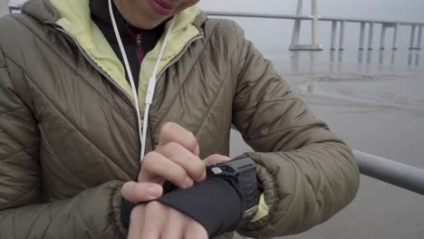 smiling hindu woman setting sport watch before running