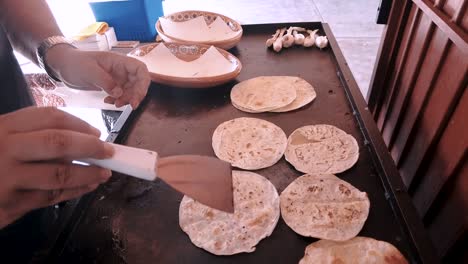 a chef is making tortilla bread in a kitchen