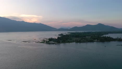 Puesta-De-Sol-Aérea-Volando-A-Través-Del-Paisaje-Asiático-Pintoresco-Y-Pacífico-Con-Lago,-Montañas-Y-Pueblo-De-Pescadores-En-Vietnam