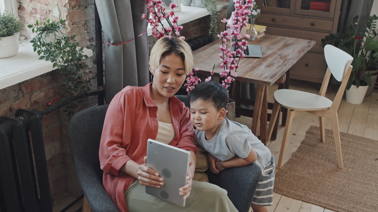 Asian Mother and Little Son Looking at Digital Tablet