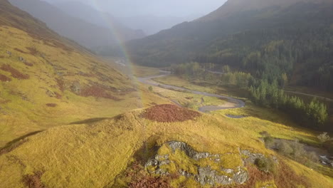flight up river finnan valley in scottish highlands with rainbow arc