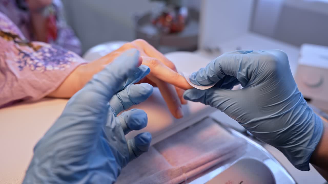 Ampia inquadratura del salone di un'estetista che esegue la pulizia finale di una manicure, catturando la cura igienica post-trattamento, il comfort del cliente e un servizio di bellezza professionale impeccabile.