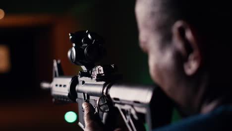 man holds rifle, enjoying shooting experience in firing range, close up