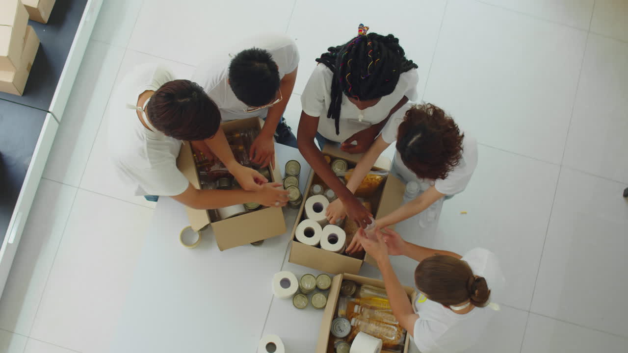 Donation Center Workers Filling Box with Necessities Top Down
