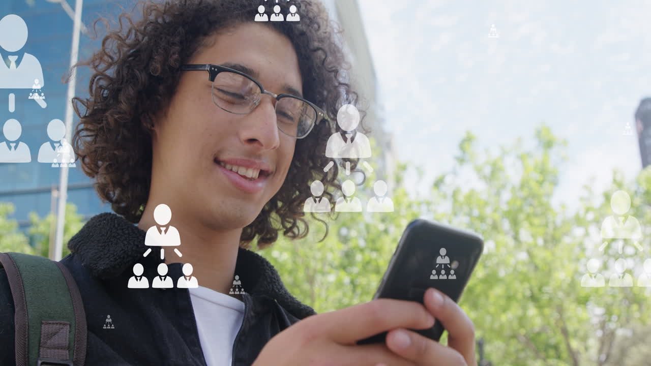 Animation of user icons over happy biracial man using smartphone in city