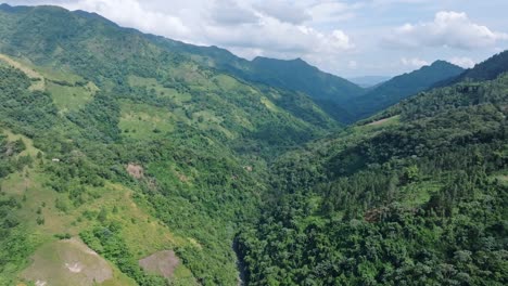 cinematic drone flight in green tropical mountains of bonao during cloudy day, dominican republic - panorama approaching shot