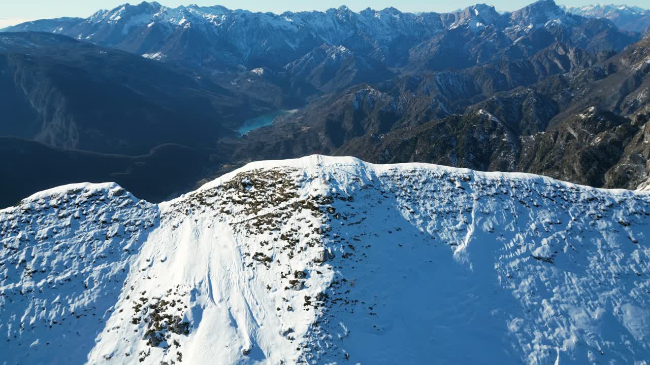 Luftaufnahmen mit einer Drohne über dem Monte Raut, Italien: klarer Dezembertag mit sonnenbeschienenen Bergkämmen und verschneiten, schattigen Hängen. Ideal für winterliches, alpines und filmreifes Stock-Videomaterial.