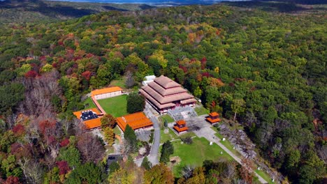 An-aerial-view-of-the-Chuang-Yen-Monastery-on-a-sunny-day,-the-leaves-of-the-trees-begin-to-change-for-autumn