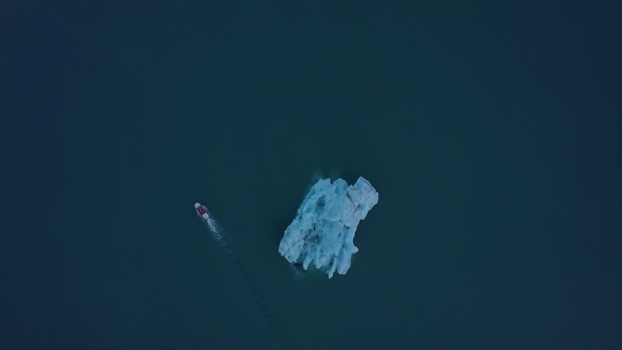 Iceberg and Boat in a Glacial Lagoon