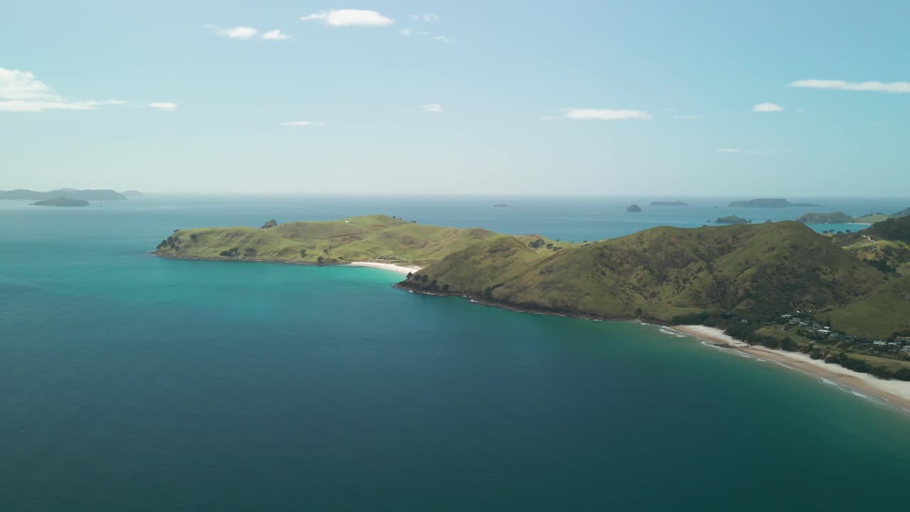 viendo las olas rodar lentamente hacia la costa en la península de coromandel