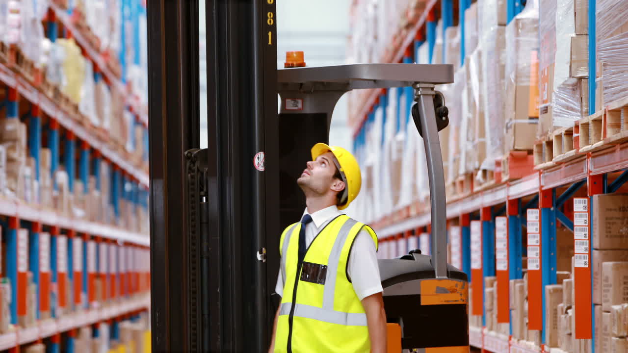 Male warehouse worker checking stock for shipping