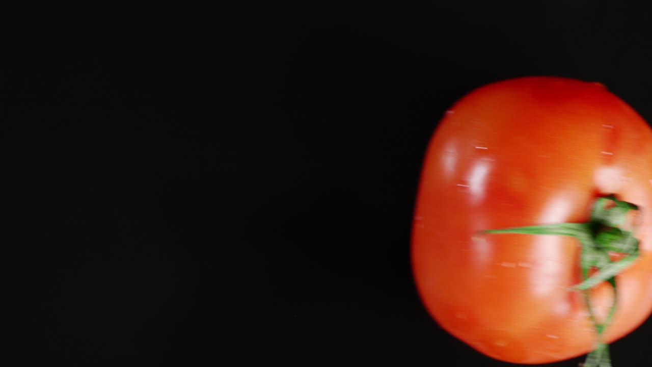 물과 함께 테이블에 익은 토마토 하나.