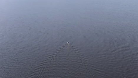 Vista-Aérea-De-Un-Bote-Pequeño-En-Un-Lago,-Rompiendo-Olas