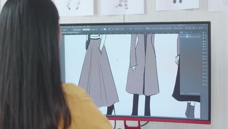 vista por encima del hombro de una diseñadora diseñando ropa en un escritorio en el estudio. concepto de procedimiento de producción de vestidos. juegos cibernéticos ropa y diseño