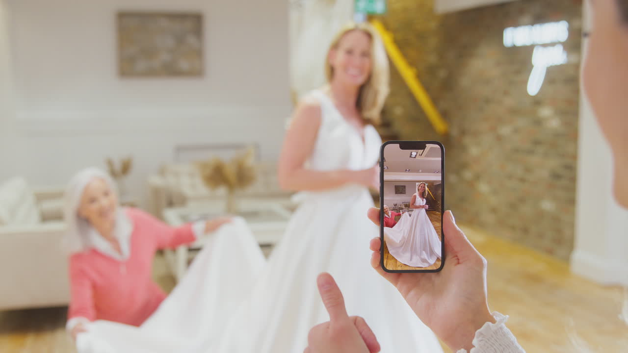 abuela con hija adulta y nieta probando el vestido de novia tomando una foto en el teléfono